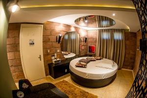 een kamer met twee bedden en een stoel erin bij Motel Hotel Paradiso - Ibirubá-RS in Ibirubá