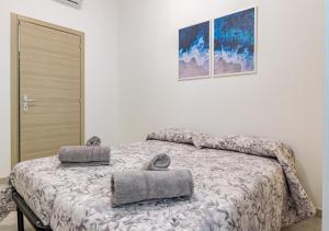 Un dormitorio con una cama con dos almohadas encima. en Urban Guest House Livorno "Port Area", en Livorno