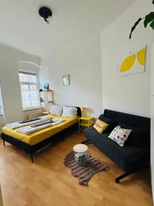 ein Wohnzimmer mit einem Bett und einer Couch in der Unterkunft hello&welcome Dresden City-Apartment in Dresden