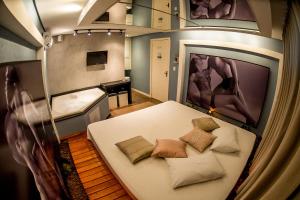 een kamer met een bed met kussens en een piano bij Motel Hotel Paradiso - Ibirubá-RS in Ibirubá