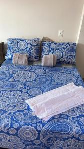 un letto con coperta e cuscini sopra di Flat mar a Coruripe