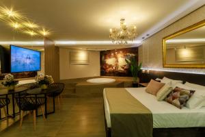 een hotelkamer met een bed en een kroonluchter bij Motel Hotel Paradiso - Ibirubá-RS in Ibirubá