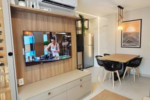 een keuken en eetkamer met een tv aan de muur bij NOVO e Impecável • 1 Quarto • pertinho do LETREIRO in Tambaú