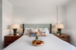 Un dormitorio con una cama con dos lámparas y una botella de vino. en Honua Kai K1024 · HK K1024 Kaanapali Beach Condo Resort Living R, en Lahaina 48 fotos más