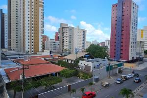 een stad met hoge gebouwen en een straat met auto's bij NOVO e Impecável • 1 Quarto • pertinho do LETREIRO in Tambaú