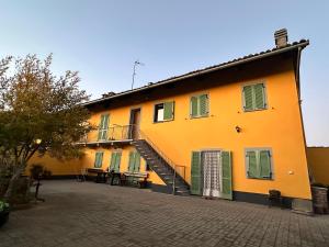 a yellow building with a staircase on the side of it at Verde Speranza Apartment in Crescentino