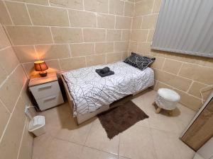 a small room with a bed and a night stand at St Anglu Xaghra - Quality Guest House in Xagħra