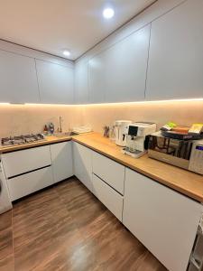 uma cozinha com armários brancos e uma bancada em Уютный Новый ХОСТЕЛ с отдельными кабинками в центре em Chişinău