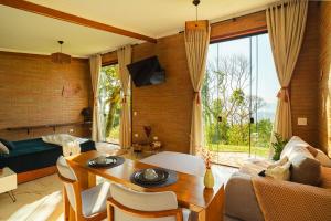 a living room with a table and a couch and a bed at Cabana nas montanhas em Campos do Jordão in Campos do Jordão