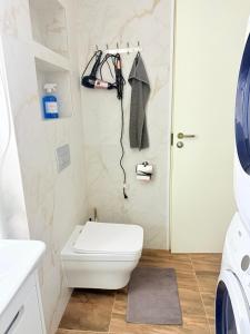 um banheiro com um vaso sanitário branco e uma pia em Уютный Новый ХОСТЕЛ с отдельными кабинками в центре em Chişinău mais 15 fotografias