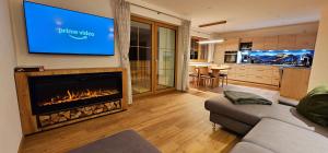 ein Wohnzimmer mit einem Kamin und einem TV an der Wand in der Unterkunft Ferienwohnungen Hipp - Bergblick und Wellness in Top Lage in Halblech