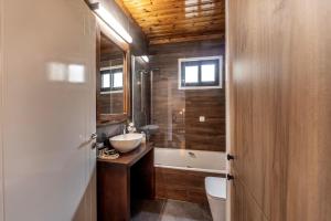 a bathroom with a sink and a toilet and a tub at Maison du Mont in Kalopanayiotis +38 photos