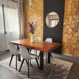 a dining room table with chairs and a vase of flowers at La Trêve Sacrée - Dakar mermoz sacrée cœur in Dakar
