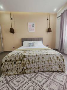 a bedroom with a large bed with a floral bedspread at La Trêve Sacrée - Dakar mermoz sacrée cœur in Dakar