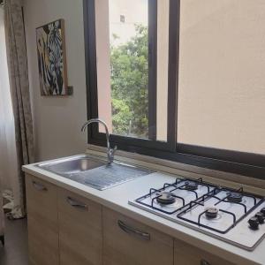 a kitchen with a stove and a sink and a window at La Trêve Sacrée - Dakar mermoz sacrée cœur in Dakar +3 photos