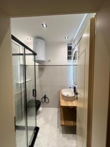 a small bathroom with a sink and a shower at Manta Apartment Albania in Golem