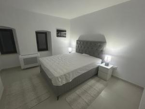 ein weißes Schlafzimmer mit einem Bett und zwei Lampen in der Unterkunft Villa Miramare Perast in Perast