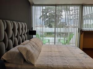 a bedroom with a large bed with a large window at Cali con amor in Cali +1 photo