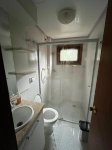 a bathroom with a shower and a toilet and a sink at Meu cantinho in Canela