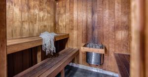 een houten sauna met een bank en een vuilnisbak bij Talisman Beachside Broadbeach in Gold Coast