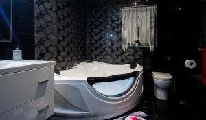 un bagno con vasca, lavandino e WC di Modern, stylish & comfortable 3 bedroom apartment with jacuzzi, aquarium and private yard with barbeque a Mellieħa Altre 45 foto