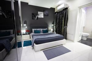 una camera con letto king-size e specchio di Modern, stylish & comfortable 3 bedroom apartment with jacuzzi, aquarium and private yard with barbeque a Mellieħa