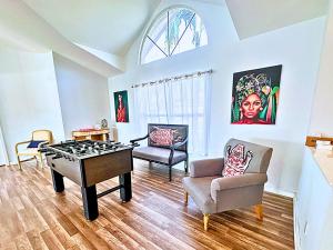 Stunning Intercoastal Waterfront Private Pool Foosball Table Tennis by Vacation Your Way في جزيرة ماركو: غرفة معيشة مع طاولة تنس وكراسي