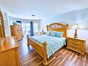 Stunning Intercoastal Waterfront Private Pool Foosball Table Tennis by Vacation Your Way في جزيرة ماركو: غرفة نوم بها سرير خشبي وخزانة ملابس وخزانة ملابس