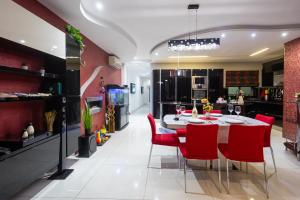 una sala da pranzo con un tavolo e sedie rosse di Modern, stylish & comfortable 3 bedroom apartment with jacuzzi, aquarium and private yard with barbeque a Mellieħa