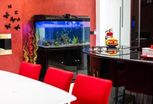 una stanza con un acquario e sedie rosse di Modern, stylish & comfortable 3 bedroom apartment with jacuzzi, aquarium and private yard with barbeque a Mellieħa