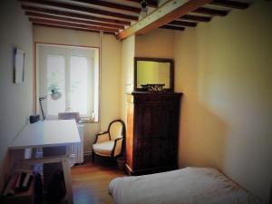 ein Schlafzimmer mit einem Bett, einem Spiegel und einem Stuhl in der Unterkunft La Roseliére in Bazenville