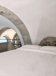 una camera con un letto bianco e due sedie di Molinu a Santu Lussurgiu