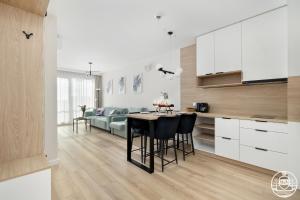 a kitchen and living room with a table and a couch at Apartments M&M, GRATIS parking, basen, sauna, siłownia in Kołobrzeg