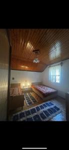 a bedroom with two beds and a wooden ceiling at Kokkotis Residence in Samarina