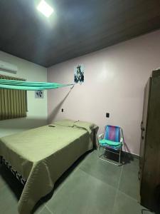 una camera con un letto e una sedia di Casa Sunset Alter a Santarém