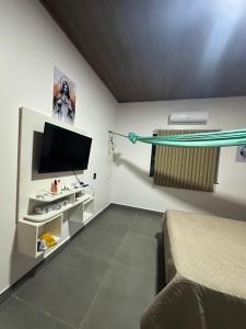 una camera da letto con un letto e una TV a schermo piatto di Casa Sunset Alter a Santarém
