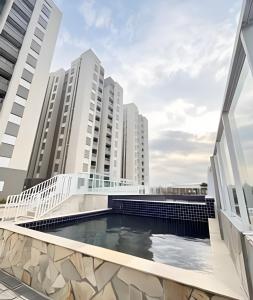 a swimming pool on the balcony of a building with tall buildings at Grace Prime Loft – Comfort in Extrema, MG in Extrema