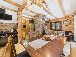 Łosia Chata في Grzybowce: غرفة طعام مع طاولة وكراسي خشبية كبيرة