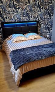 un letto con piumone blu e bianco in una camera da letto di Le Square Inn a Turckheim