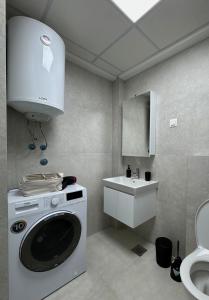 Un baño con lavadora y lavabo. en Harmony Airport Apartment, en Skopje