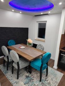 a dining room with a wooden table and blue chairs at Vila Dunja Pale in Pale +15 photos