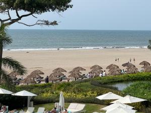 una spiaggia con ombrelloni e persone sulla spiaggia di 2 bedroom Grand Luxxe a Nuevo Vallarta