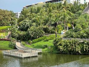 un fiume con una passerella in un parco con palme di 2 bedroom Grand Luxxe a Nuevo Vallarta