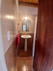 een badkamer met een wastafel en een spiegel bij La Chakana in Capilla del Monte