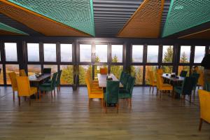 a dining room with tables and chairs and windows at Hotel Planinska Kraljica Jahorina - Pale in Gornje Pale