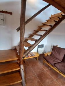 een woonkamer met een houten trap en een bank bij La Chakana in Capilla del Monte