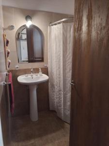 een badkamer met wastafel en douche met spiegel bij La Chakana in Capilla del Monte +19 foto's