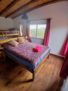 een slaapkamer met een bed met een paars dekbed bij La Chakana in Capilla del Monte