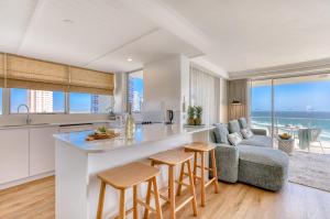 a kitchen and living room with a view of the ocean at Talisman Beachside in Gold Coast