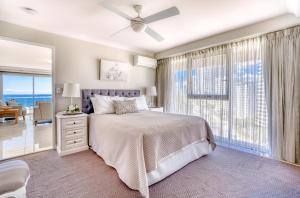 a bedroom with a bed and a view of the ocean at Talisman Beachside in Gold Coast